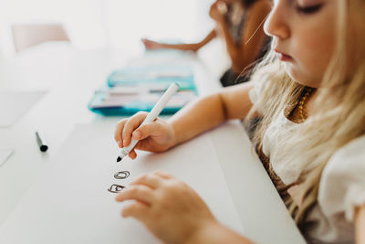 Close up of young girl drawing circles with marker on paper