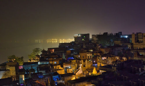 High angle view of illuminated buildings against sky at night