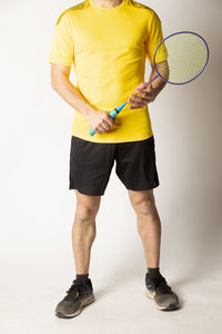 Full length of man standing against yellow background