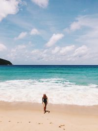 Woman on beach against sky