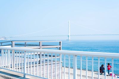 Tourists on bridge over sea