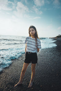 Full length portrait of young woman standing on beach