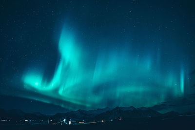 Scenic view of snowcapped mountains against sky at night