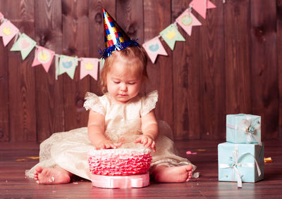 Cute baby girl playing with cake