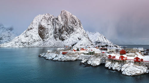 Scenic view of snowcapped mountains by sea against sky