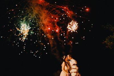 Low angle view of fireworks against sky at night