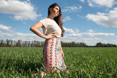 Rear view of woman standing on field against sky