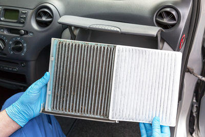 Midsection of man repairing air conditioner in car