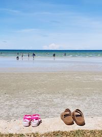 Deck chairs on beach against sky