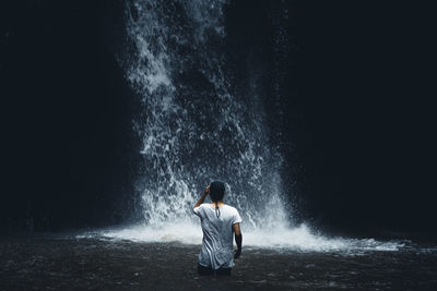 Rear view of man against waterfall