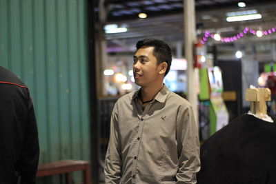 Young man looking at illuminated camera