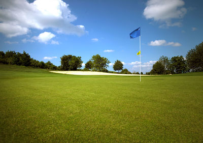 Scenic view of golf course against sky