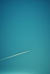 Low angle view of vapor trail in blue sky