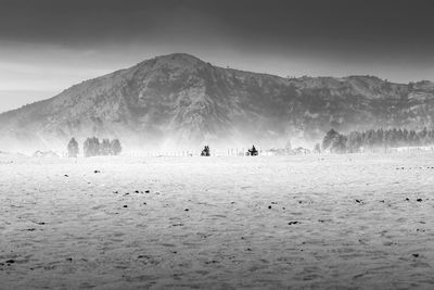 Group of people on land against mountain range