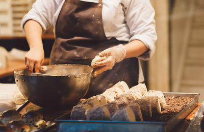 Midsection of female chef preparing food on table