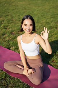 Portrait of young woman sitting on field