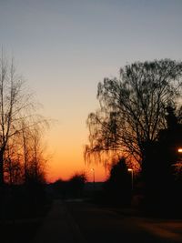 Silhouette bare trees against clear sky at sunset