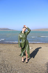 Boy standing on beach against sky