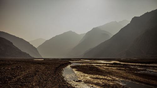 Scenic view of land and mountains against sky