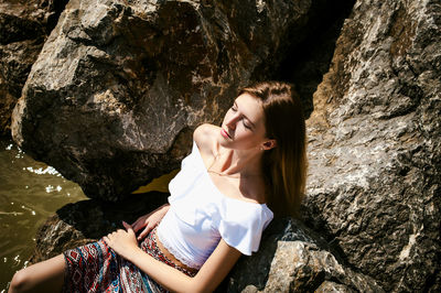 Young woman sitting on rock