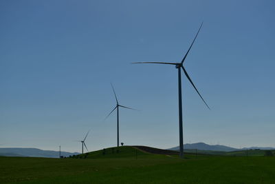 Windmill on field against clear sky