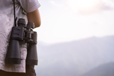 Midsection of man holding camera