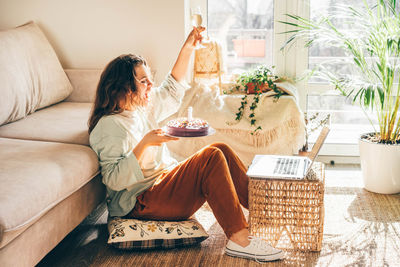 Woman sitting on sofa at home