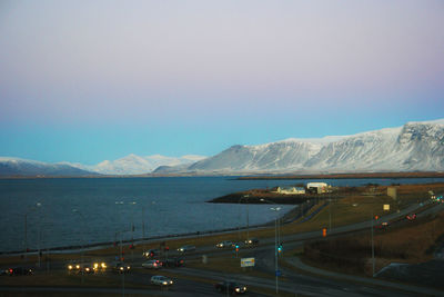 Scenic view of sea by mountains against sky