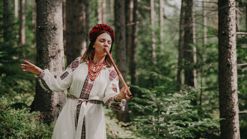 Portrait of young woman standing in forest