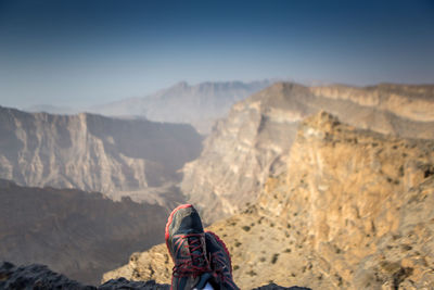 Low section of man wearing shoes on mountain against sky