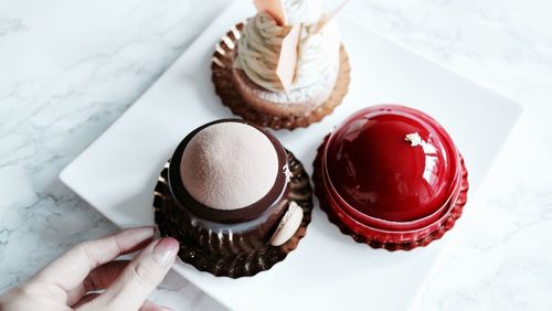 High angle view of hand holding ice cream on table