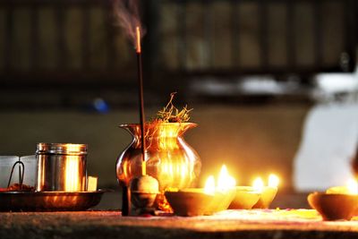 Close-up of illuminated diyas on table