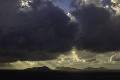 Scenic view of storm clouds over silhouette landscape