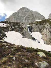 Scenic view of rocky mountains and ice waterfall 