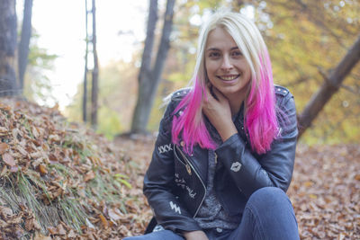 Portrait of smiling woman with dyed hair at forest