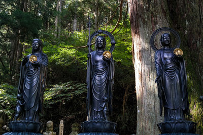 Statue amidst trees in forest