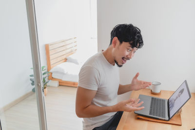 Young man using mobile phone at home