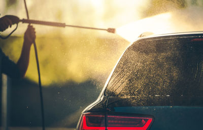 Cropped hand of man cleaning car at garage