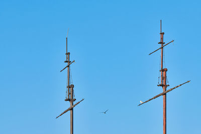 Low angle view of wind turbine against clear blue sky