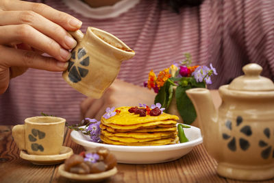 Close-up of hand holding tea cup on table