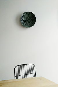 Empty table against decor mounted on white wall