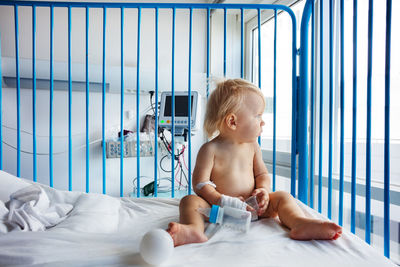 Portrait of cute baby boy lying on bed at home