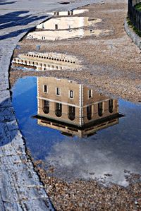 Reflection of historic building on puddle