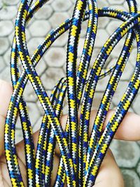 High angle view of man holding multi colored braided rope