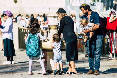 Group of people walking on street in city