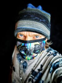 Close-up portrait of young man against black background