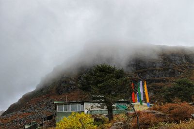 View of building on mountain against cloudy sky