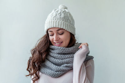 Portrait of smiling young woman against white background