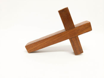 High angle view of cross on wood against white background