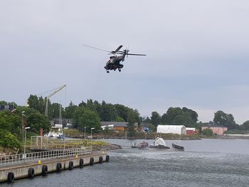 Airplane flying over river against sky